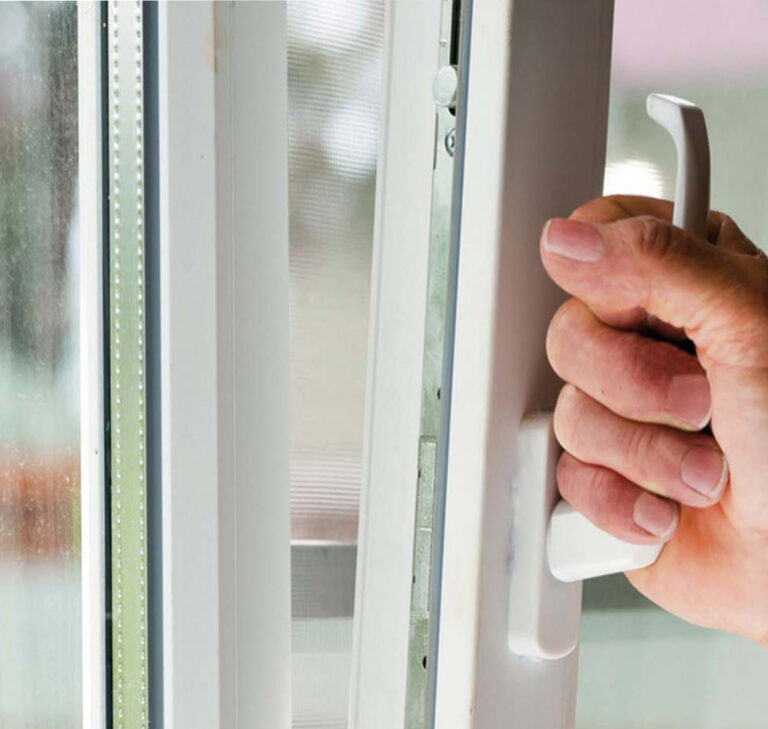 Zoom sur une main masculine ouvrant une fenêtre blanche à ouverture oscillo-battante.