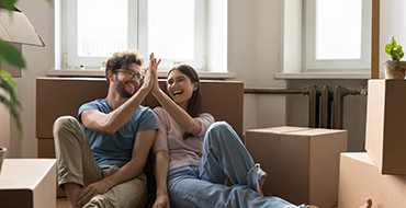 Couple heureux assis par terre dans leur nouvel appartement