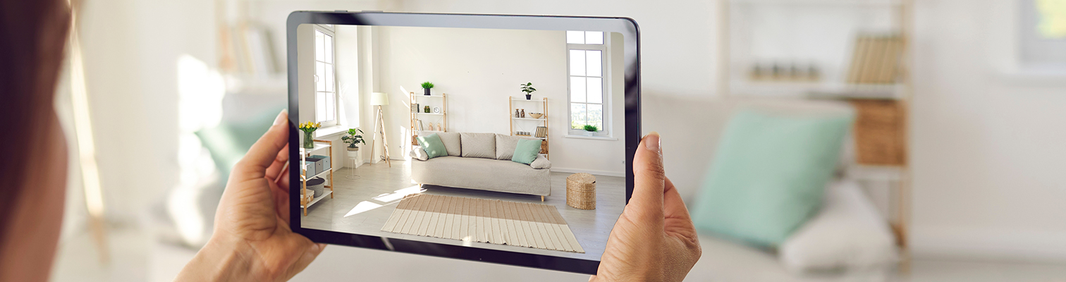 Femme tenant une tablette devant elle en train de configurer ses menuiseries et de regarder le rendu chez elle