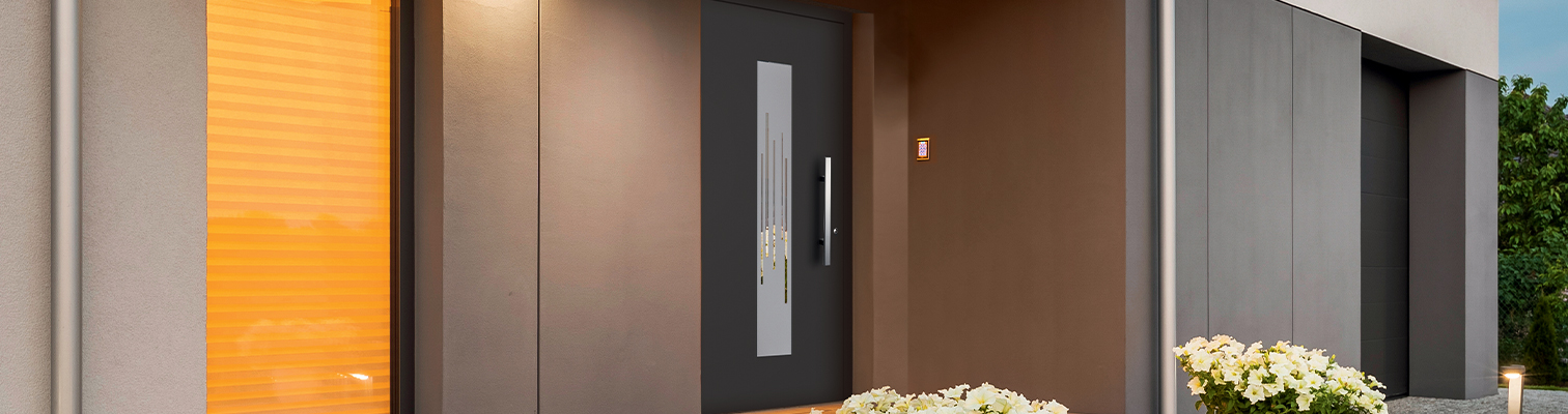 Vue extérieure en panorama de la façade d'une maison contemporaine avec une porte d'entrée Prestige AMCC