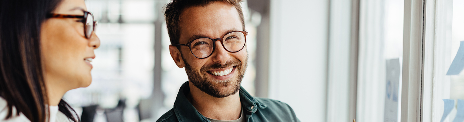 Homme souriant devant ses nouvelles fenêtres à l'intérieur de sa maison
