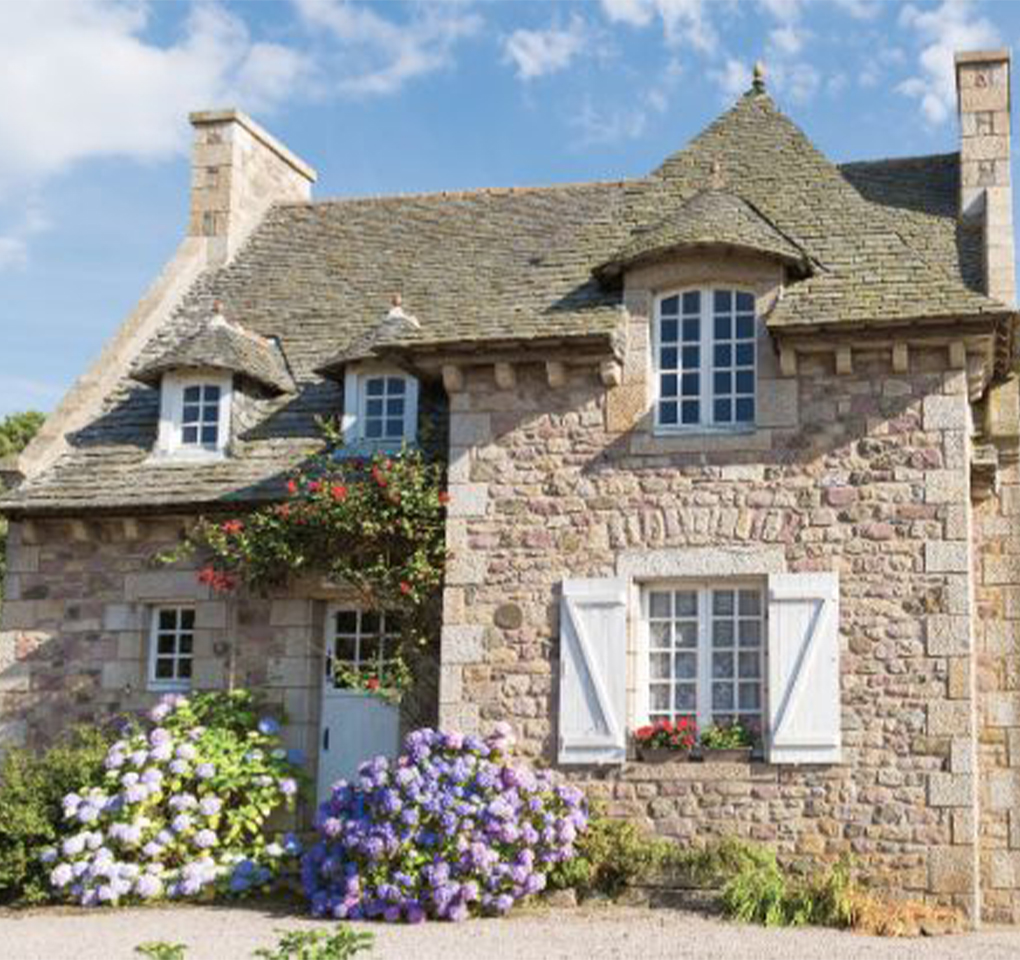 Vue extérieure d'une maison ancienne charmante avec pierre apparente et pierre de taille, fenêtres à rénover