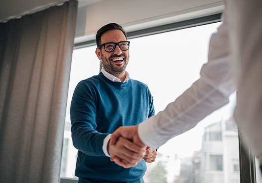 Homme souriant qui fait un poignée de main à un autre homme