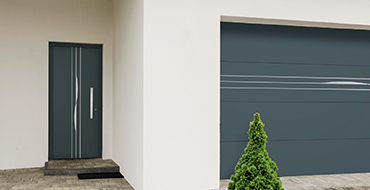 Vue extérieure d'une façade de maison actuelle avec une porte d'entrée sobre Prestige moderne modèle Cantate AMCC