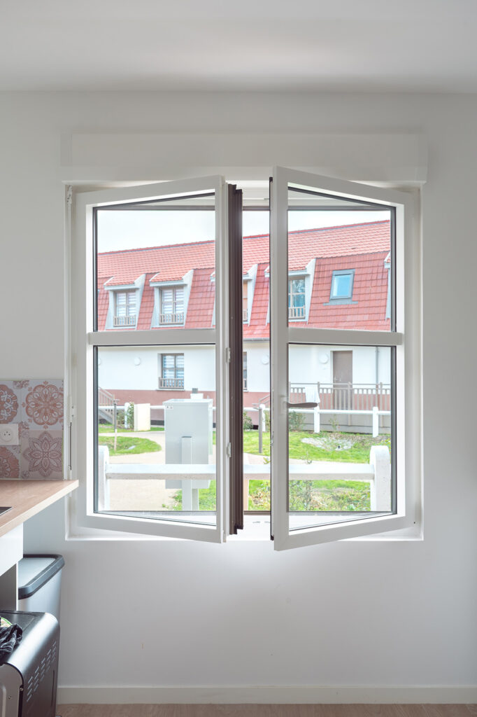 Photo d'une fenêtre mixte pvc-aluminium gamme Alya entrouverte dans une cuisine neuve