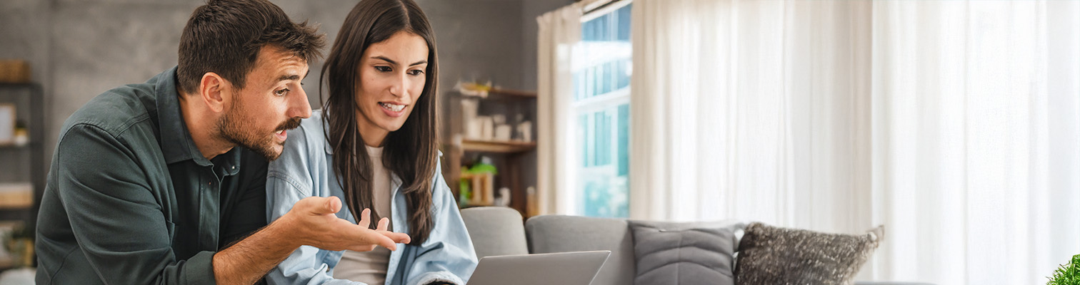 couple dans son salon en train de regarder une tablette et de comparer les portes AMCC sur internet