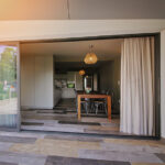 baie vitrée coulissante a galandage cg70 élégance amcc devant une terrasse