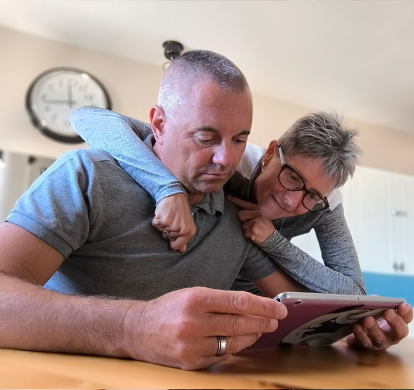 photo d'un couple d'une cinquantaine d'année consultant le catalogue fenêtres et ouvertures amcc sur une tablette
